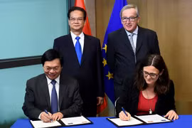 Bộ trưởng Công Thương Vũ Huy Hoàng và Cao ủy Thương mại EU Cecilia Malmstrom ký Tuyên bố về việc chính thức kết thúc đàm phán EVFTA. (Nguồn: AFP)
