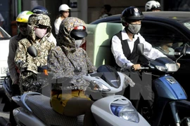 Người dân phải trang bị đầy đủ các trang phục tránh nắng nóng mỗi khi ra đường trong những ngày nắng nóng. (Ảnh: Trần Thanh Giang/TTXVN)