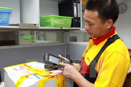 Nhân viên DHL dùng máy quét mã vạch không dây để quản lý hàng hóa. (Ảnh: Minh Tú/TTXVN)