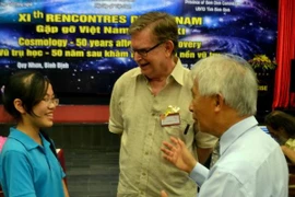 Giáo sư George F. Smoot (giữa) giao lưu cùng học sinh Đinh Thị Hương Thảo, Huy chương vàng Olympic quốc tế môn Vật lý (trái). (Ảnh: Quốc Dũng/TTXVN)