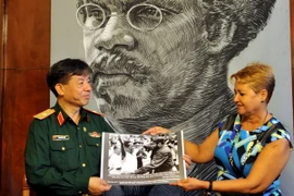 Thiếu tướng Phạm Văn Huấn trao tặng bức ảnh lịch sử về chuyến thăm Việt Nam của Chủ tịch Fidel Castro cho Phó Chủ tịch thứ nhất Upec Aixa Hevia. (Ảnh: Lê Hà/TTXVN) 