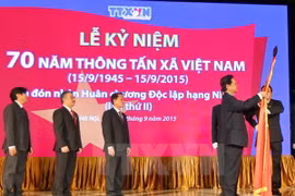 Thủ tướng Nguyễn Tấn Dũng gắn Huân chương Độc lập hạng Nhất lên Cờ truyền thống của Thông tấn xã Việt Nam. (Ảnh: Đức Tám/TTXVN)