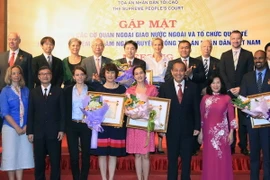 Chánh án Tòa án nhân dân tối cao Trương Hòa Bình trao tặng kỷ niệm chương cho các cá nhân tiêu biểu. (Ảnh: Doãn Tấn/TTXVN)