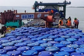 Lực lượng chức năng kiểm tra chiếc sà lan chở gần 200.000 lít dầu không rõ nguồn gốc. (Ảnh: Công Trí/Vietnam+)