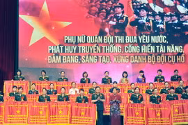Thượng tướng Ngô Xuân Lịch và Chủ tịch Hội Liên hiệp Phụ nữ Việt Nam Nguyễn Thị Thanh Hòa tặng Cờ Thi đua của Tổng cục Chính trị cho các gương phụ nữ điển hình tiên tiến. (Ảnh: Trọng Đức/TTXVN)