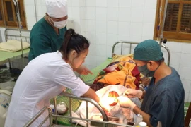 Các y, bác sỹ cấp cứu cho ngư dân Nguyễn Văn Thịnh. (Ảnh: Nguyễn Đức Quân/TTXVN) 