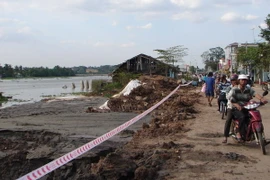 Sạt lở bờ sông Sài Gòn trên đường Nguyễn Tri Phương, lực lượng chức năng thành phố Thủ Dầu Một phải tiến hành căng dây cảnh báo nguy hiểm. (Nguồn: TTXVN) 