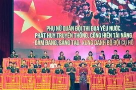 Thượng tướng Ngô Xuân Lịch và Chủ tịch Hội Liên hiệp Phụ nữ Việt Nam Nguyễn Thị Thanh Hòa tặng Cờ Thi đua của Tổng cục Chính trị cho các gương phụ nữ điển hình tiên tiến. (Ảnh: Trọng Đức/TTXVN)