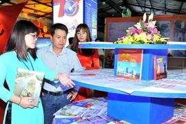 Khách tham quan tại gian hàng các ấn phẩm của TTXVN. (Ảnh: Minh Đức/TTXVN)