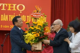 Bí Thư Thành ủy Hà Nội Phạm Quang Nghị tặng hoa giáo sư Vũ Khiêu. (Ảnh: Đinh Thị Thuận/TTXVN)