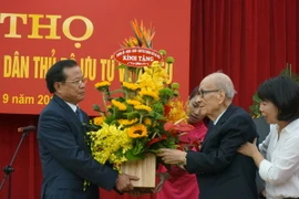 Bí Thư Thành ủy Hà Nội Phạm Quang Nghị tặng hoa giáo sư Vũ Khiêu. (Ảnh: Đinh Thị Thuận/TTXVN)