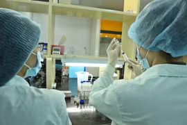 Nhân viên Công ty TNHH Một thành viên Vaccine và Sinh phẩm số 1 (VABIOTECH) thử nghiệm định lượng Protein trong vaccine ngừa COVID-19. (Ảnh: Minh Quyết/TTXVN)