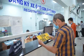 Cấp, đổi biển số nền màu vàng cho người dân. (Ảnh: Thành Chung/TTXVN)