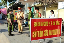 Lực lượng chức năng làm nhiệm vụ tại chốt phòng dịch tại Sóc Trăng. (Ảnh: Trung Hiếu/TTXVN)
