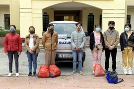 Đối tượng Vi Văn Thêm (đứng giữa) và các đối tượng xuất cảnh trái phép. (Ảnh Thái Thuần/TTXVN)