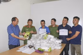 Hai đối tượng Hoàng Mạnh Linh và Lò Lả cùng tang vật tại cơ quan điều tra. (Ảnh: Xuân Tư/TTXVN)