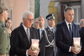 Tổng thống Đức Frank-Walter Steinmeier và Tổng thống Ba Lan Andrzej Duda thắp nến tưởng nhớ các nạn nhân. (Ảnh: PAP/TTXVN)