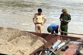 Lực lượng chức năng kiểm tra, xử lý các tàu hút cát trái phép trên sông Lam. (Ảnh: TTXVN phát) 