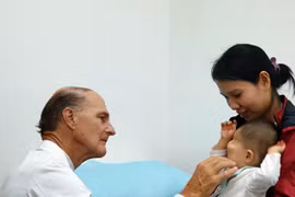 Bác sỹ McKay McKinnon khám lâm sàng cho một trẻ em bị dị dạng hốc mắt. (Ảnh: TTXVN phát)