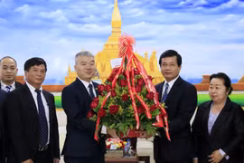 Đại biện Nguyễn Thanh Tùng chúc mừng Phó Trưởng Ban Đối ngoại Trung ương Lào Somphone Sichaleun. (Ảnh: Phạm Kiên/TTXVN)