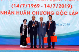Thủ tướng Nguyễn Xuân Phúc tặng quà cho nguyên Giám đốc Bệnh viện Nhi Trung ương qua các thời kỳ. (Ảnh: Thống Nhất/TTXVN) 