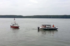 Các lực lượng chức năng vẫn túc trực tại hiện trường để ứng phó sự cố trên sông Lòng Tàu. (Ảnh: TTXVN phát)