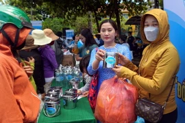 Hội Phụ nữ thành phố Hội An đang thu, đổi rác thải nhựa dùng một lần, vỏ lon bia, nước ngọt… đổi các sản phẩm gia dụng tại hội thi. (Ảnh: Trịnh Bang Nhiệm/TTXVN)
