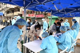 Người dân xếp hàng chờ tiêm vaccine ngừa COVID-19 tại Hong Kong, Trung Quốc. (Ảnh: THX/TTXVN)