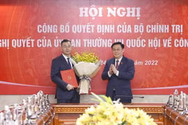Chủ tịch Quốc hội Vương Đình Huệ trao Quyết định của Bộ Chính trị và tặng hoa ông Ngô Văn Tuấn. (Ảnh: Doãn Tấn/TTXVN)