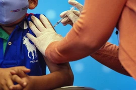 Tiêm vaccine ngừa COVID-19 cho trẻ em tại bệnh viện. (Ảnh: AFP/TTXVN)