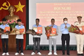Ông Lê Ngọc Linh, Bí thư Huyện ủy Long Điền, tỉnh Bà Rịa-Vũng Tàu (thứ 2 từ phải qua) trao thư khen và tiền thưởng cho các cá nhân dũng cảm tham gia cứu hộ. (Ảnh: TTXVN phát)