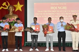 Ông Lê Ngọc Linh, Bí thư Huyện ủy Long Điền, tỉnh Bà Rịa-Vũng Tàu (thứ 2 từ phải qua) trao thư khen và tiền thưởng cho các cá nhân dũng cảm tham gia cứu hộ. (Ảnh: TTXVN phát)