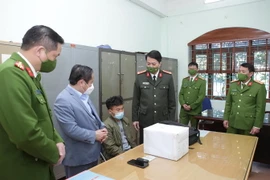 Phó Chủ tịch Thường trực Ủy ban Nhân dân tỉnh Lai Châu Tống Thanh Hải cùng Giám đốc Công an tỉnh Lai Châu Nguyễn Viết Giang kiểm tra tang vật cùng đối tượng vận chuyển trái phép chất ma túy. (Ảnh: Quý Trung/TTXVN)