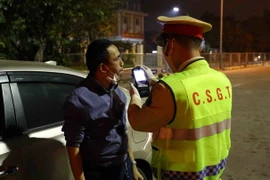 Kiểm tra nồng độ cồn với các tài xế lái xe đường dài tại trạm thu phí Pháp Vân-Cầu Giẽ. (Ảnh: Phạm Kiên/TTXVN)