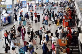 Hành khách làm thủ tục lên máy bay tại khu vực của hãng hàng không Vietjet ở Cảng Hàng không quốc tế Nội Bài. (Ảnh: Huy Hùng/TTXVN)