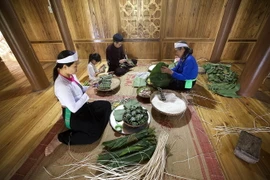 Gia đình quây quần gói bánh chưng, bánh ống trên nếp nhà sàn trong những ngày lễ, Tết là một nét đẹp văn hóa riêng có của người Mường tỉnh Hòa Bình. (Ảnh: Trọng Đạt/TTXVN)