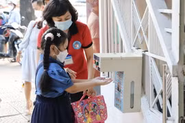 Học sinh trường tiểu học Hòa Bình, quận 1, được giáo viên hướng dẫn rửa tay trước khi vào lớp. (Ảnh: Hồng Giang/TTXVN)