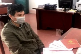 Đối tượng Lê Văn Tuấn và các sổ sách, chứng từ liên quan việc cho vay nặng lãi. (Ảnh: TTXVN phát)