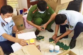 Lực lượng chức năng kiểm đếm số thuốc tạm giữ tại một nhà thuốc. (Ảnh: TTXVN phát)