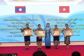 Bà Hà Thị Nga, Ủy viên Trung ương Đảng, Chủ tịch Hội Liên hiệp Phụ nữ Việt Nam trao tặng Huân chương, Huy chương cho các tập thể, cá nhân Hội Liên hiệp Phụ nữ Lào. (Ảnh: Trần Lê Lâm/TTXVN)