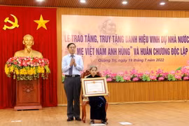 Phó Bí thư Thường trực Tỉnh ủy, Chủ tịch HĐND tỉnh Quảng Trị Nguyễn Đăng Quang trao danh hiệu "Bà mẹ Việt Nam Anh hùng” cho bà Lê Thị Mót, xã Gio Sơn, huyện Gio Linh. (Ảnh: Nguyên Lý/TTXVN)