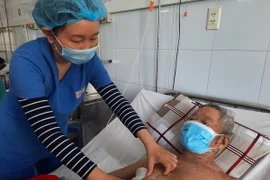 Bác sỹ thăm khám bệnh nhân sau phẫu thuật. (Ảnh: TTXVN phát)