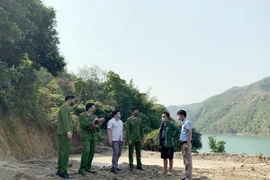 Lực lượng chức năng lập biên bản đình chỉ hoạt động của bãi tập kết cát trái phép tại xã Tạ Khoa, huyện Bắc Yên. (Ảnh: Hữu Quyết/TTXVN)