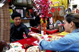 Viết câu đối tết, viết thư pháp chúc mừng năm mới luôn thu hút sự quan tâm của người đi xin chữ đầu năm mới. (Ảnh tư liệu: Hồng Nhung/TTXVN)