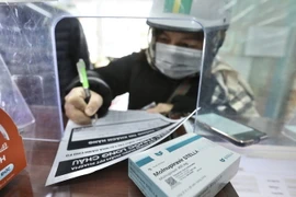 Người dân đi mua thuốc Molnupiravir điều trị COVID-19. (Ảnh: Minh Quyết/TTXVN)