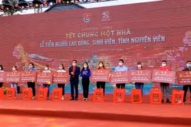 Trao vé tàu, xe, máy bay cùng các phần quà Tết cho đại diện sinh viên, công nhân tại chương trình. (Ảnh: Hồng Giang/TTXVN)