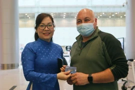 Nhân viên VNPT Đà Nẵng tặng và hướng dẫn du khách quốc tế sử dụng sim điện thoại miễn phí được tặng khi vừa đến Sân bay quốc tế Đà Nẵng. (Ảnh: Trần Lê Lâm/TTXVN)