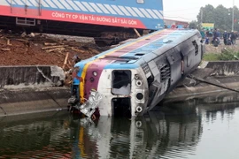 Vụ tai nạn khiến toa đầu máy bị văng xuống mương. (Ảnh: Đại Nghĩa/TTXVN)