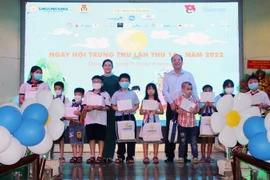 Đại diện Lãnh đạo UBND Thành phố Hồ Chí Minh, sở ngành, đoàn thể và Ban tổ chức trao quà cho các em thiếu nhi tham gia Ngày hội Trung thu lần thứ 16 năm 2022. (Ảnh:Trần Thị Mỹ Phương/TTXVN)