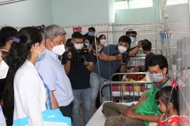 Thứ trưởng Bộ Y tế Nguyễn Trường Sơn kiểm tra công tác thu dung, điều trị bệnh nhân sốt xuất huyết tại Bệnh viện quận 8, Thành phố Hồ Chí Minh. (Ảnh: Đinh Hằng/TTXVN)